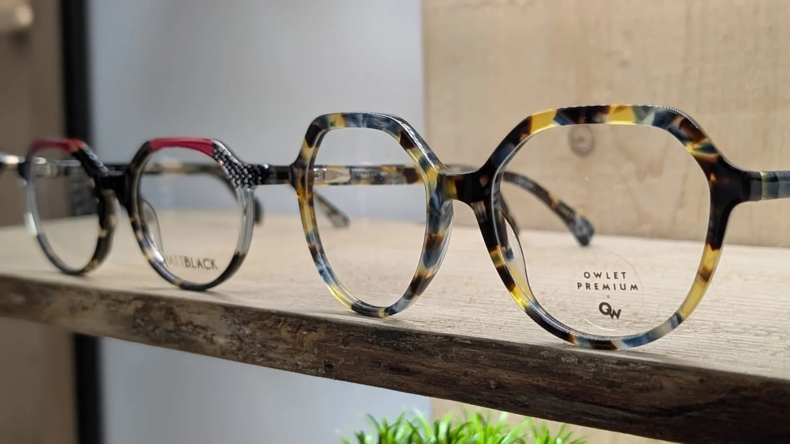 Gafas graduadas de acetato en el expositor de madera de Siente