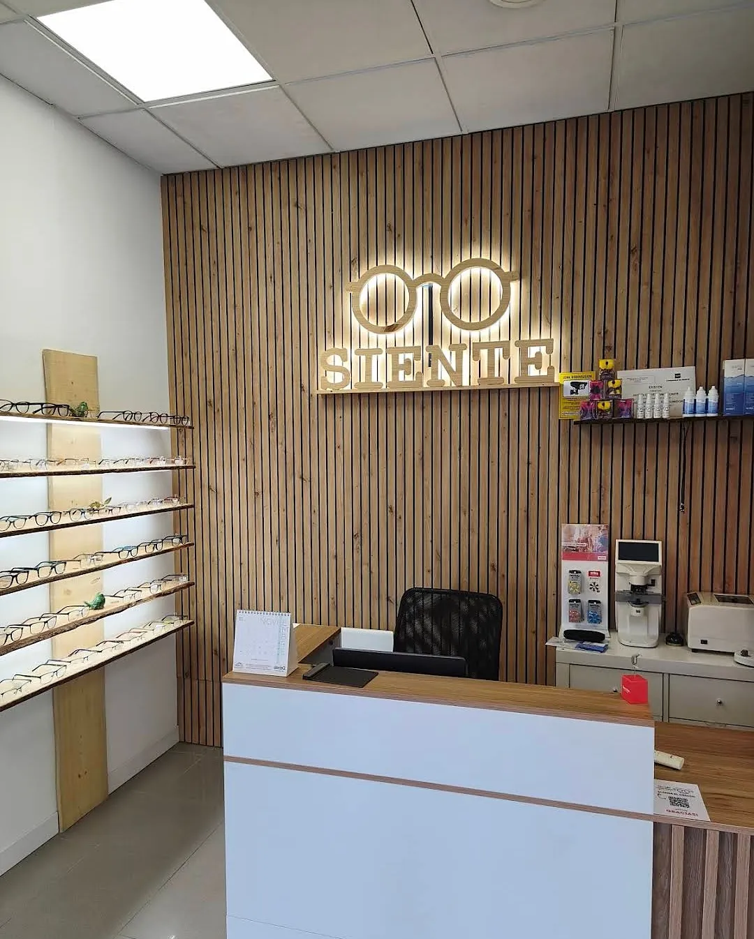 Recepción de Siente con el rótulo de madera iluminado sobre la pared de listones